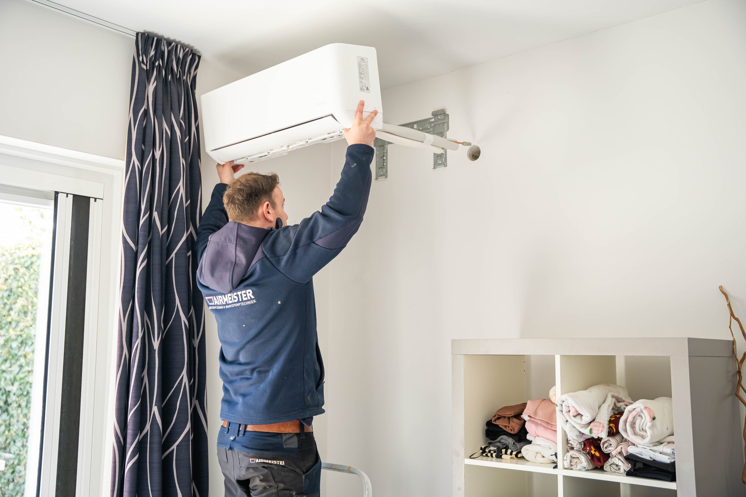 Qventi airconditioning installatie met monteur verlengde koelleiding door muur